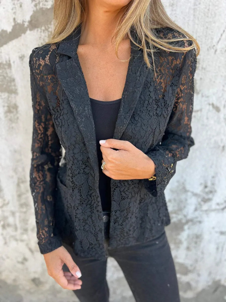 Vrouw draagt een zwarte kanten blazer met bloemendessin, perfect als licht jasje voor een stijlvolle look.