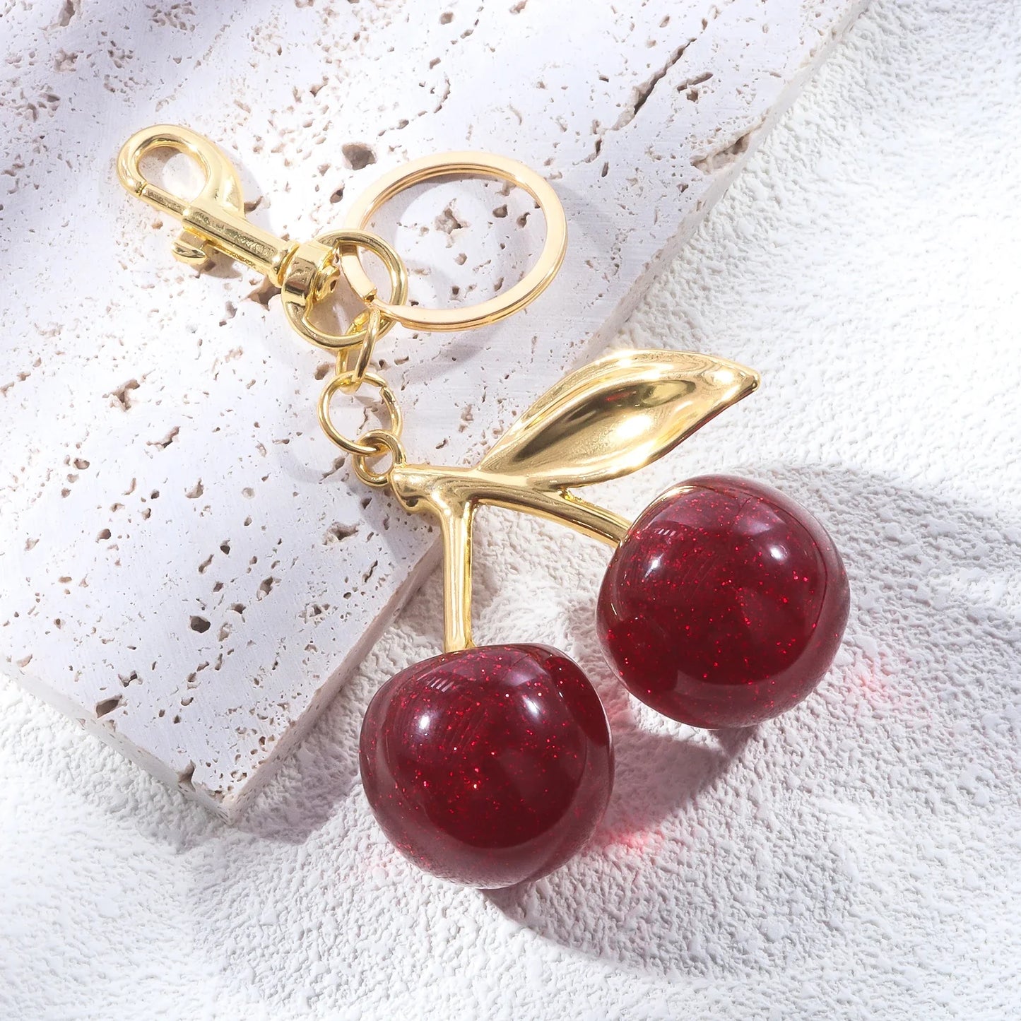 Kersen sleutelhanger dames – glanzend accessoire met gouden details en rode glitterkersen