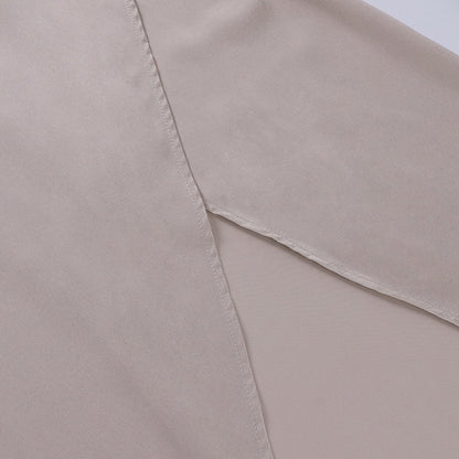 Model draagt een katoenen jurk met watervalhals en hoge split, ideaal voor een zomerse en stijlvolle look.