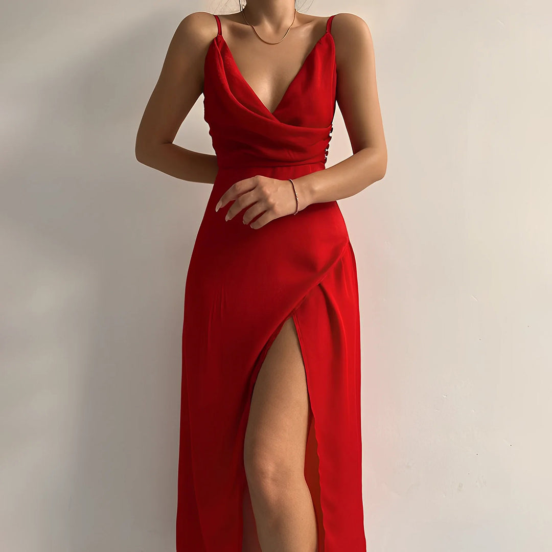 Model draagt een katoenen jurk met watervalhals en hoge split, ideaal voor een zomerse en stijlvolle look.
