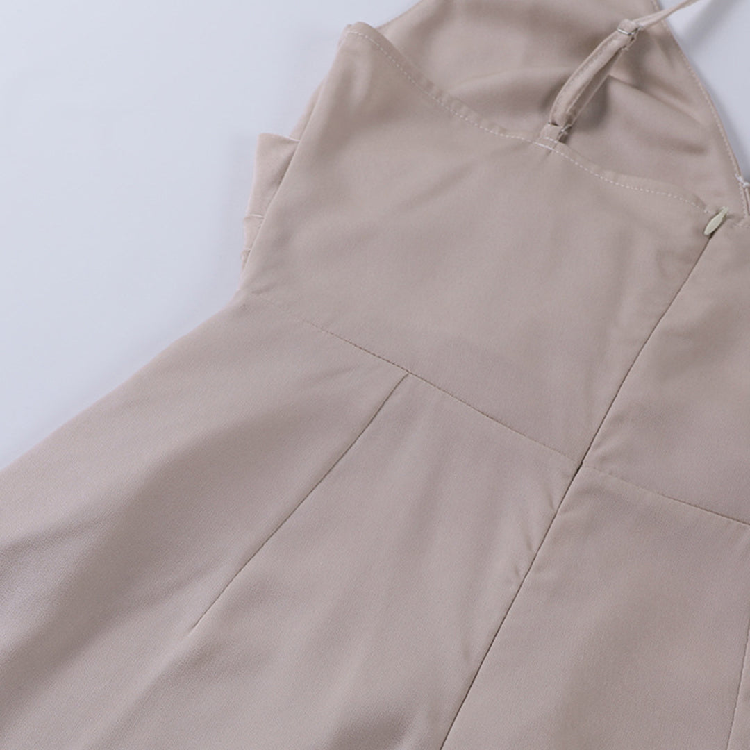 Model draagt een katoenen jurk met watervalhals en hoge split, ideaal voor een zomerse en stijlvolle look.
