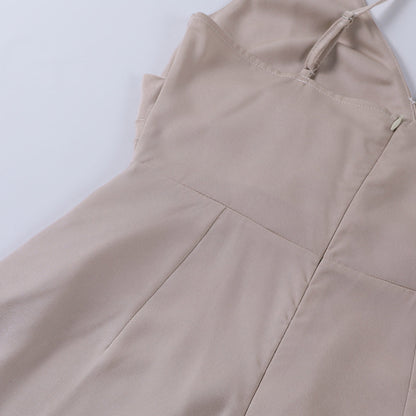 Model draagt een katoenen jurk met watervalhals en hoge split, ideaal voor een zomerse en stijlvolle look.
