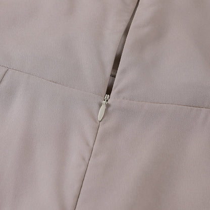 Model draagt een katoenen jurk met watervalhals en hoge split, ideaal voor een zomerse en stijlvolle look.