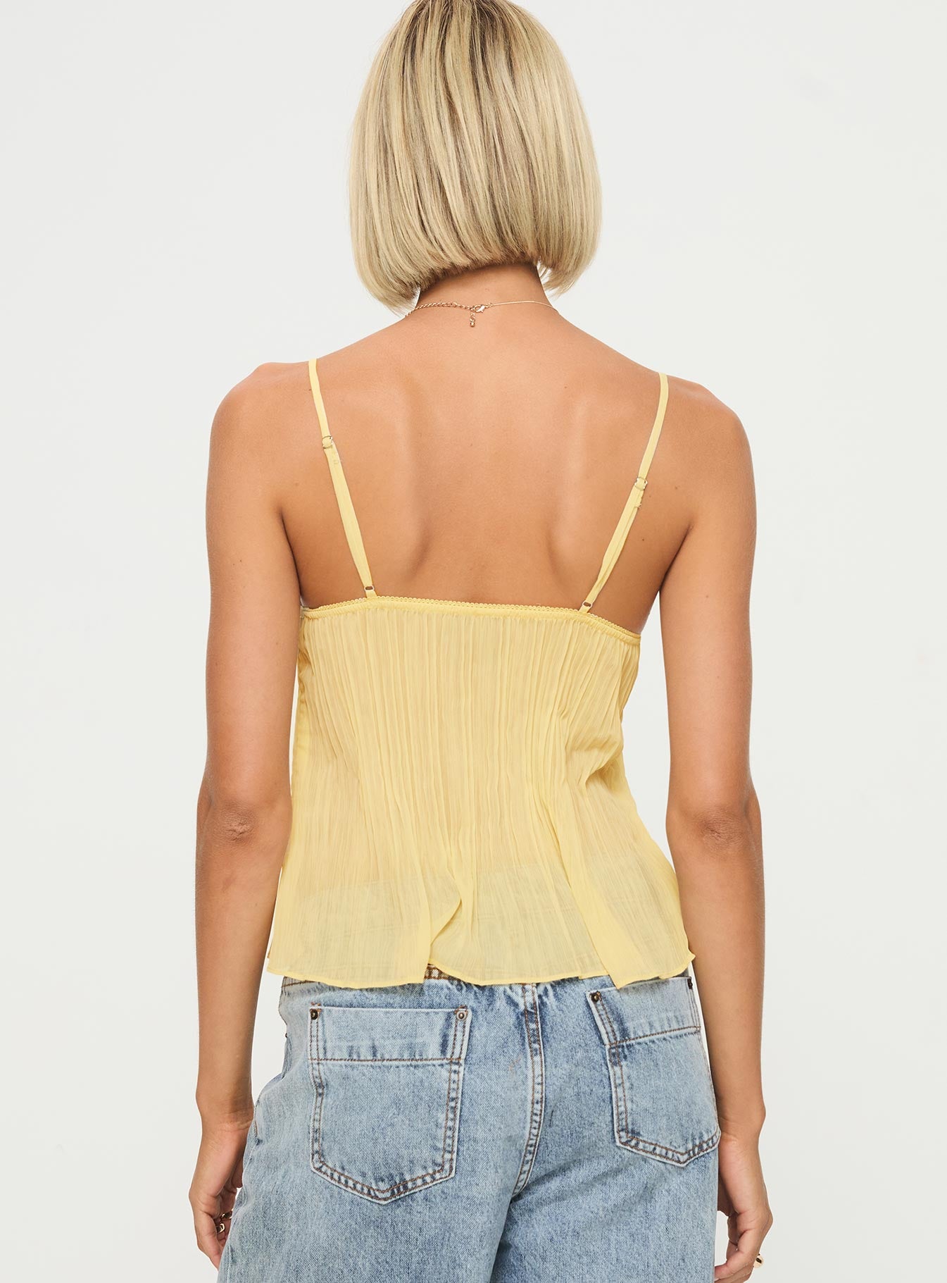 Plissé top met kant – luchtige zomerse top met dunne bandjes en elegante details.