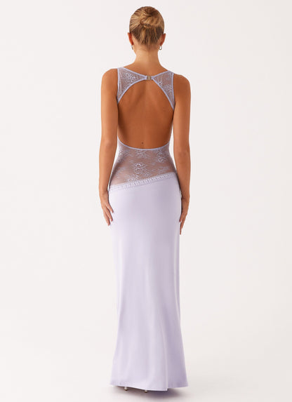 Model draagt een lila maxi-jurk met kanten inzetstuk rond de taille – elegante en moderne avondjurk in een verfijnd ontwerp.