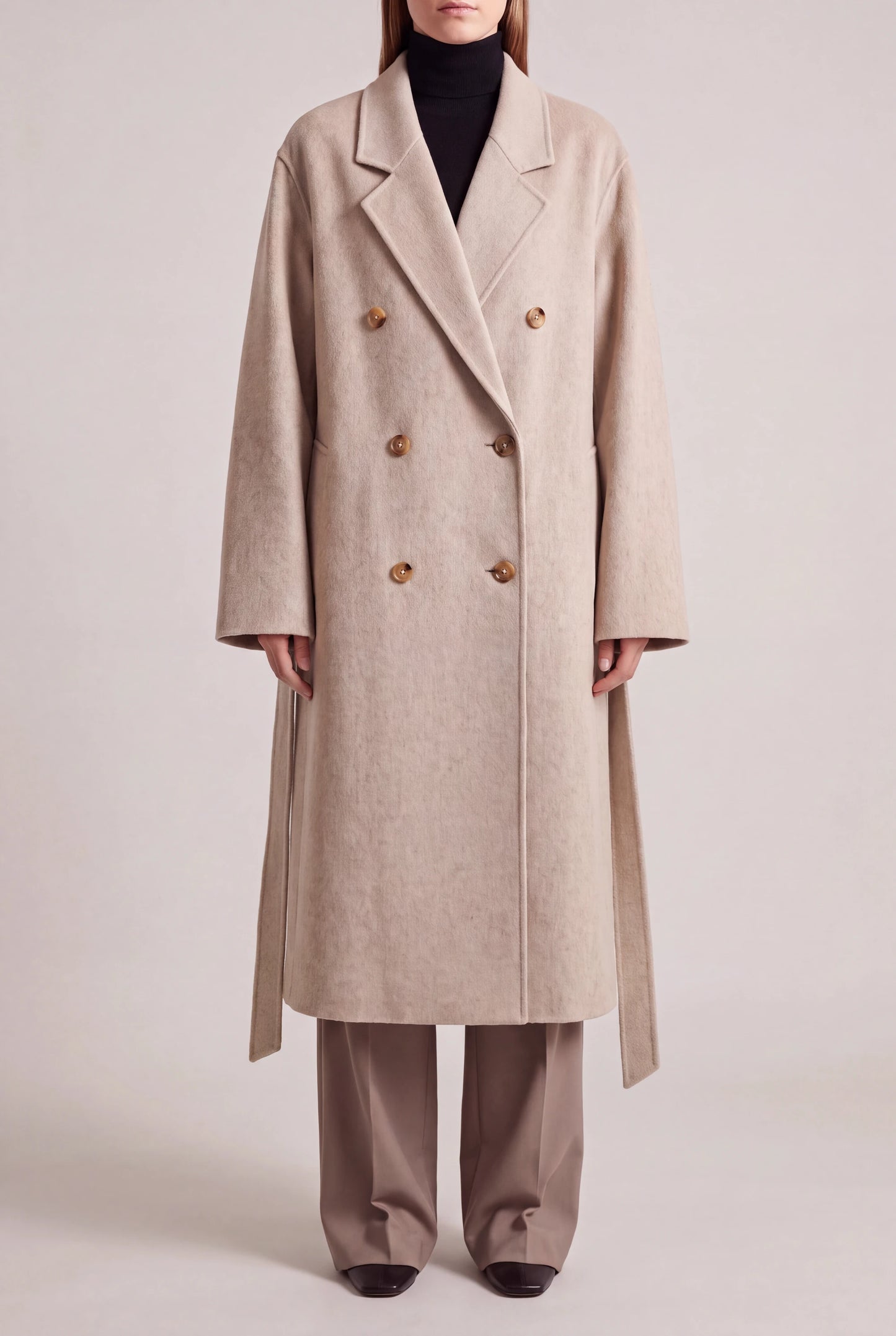 ORABEL lange winterjas voor dames in beige - vooraanzicht met losse ceintuur langs de heupen