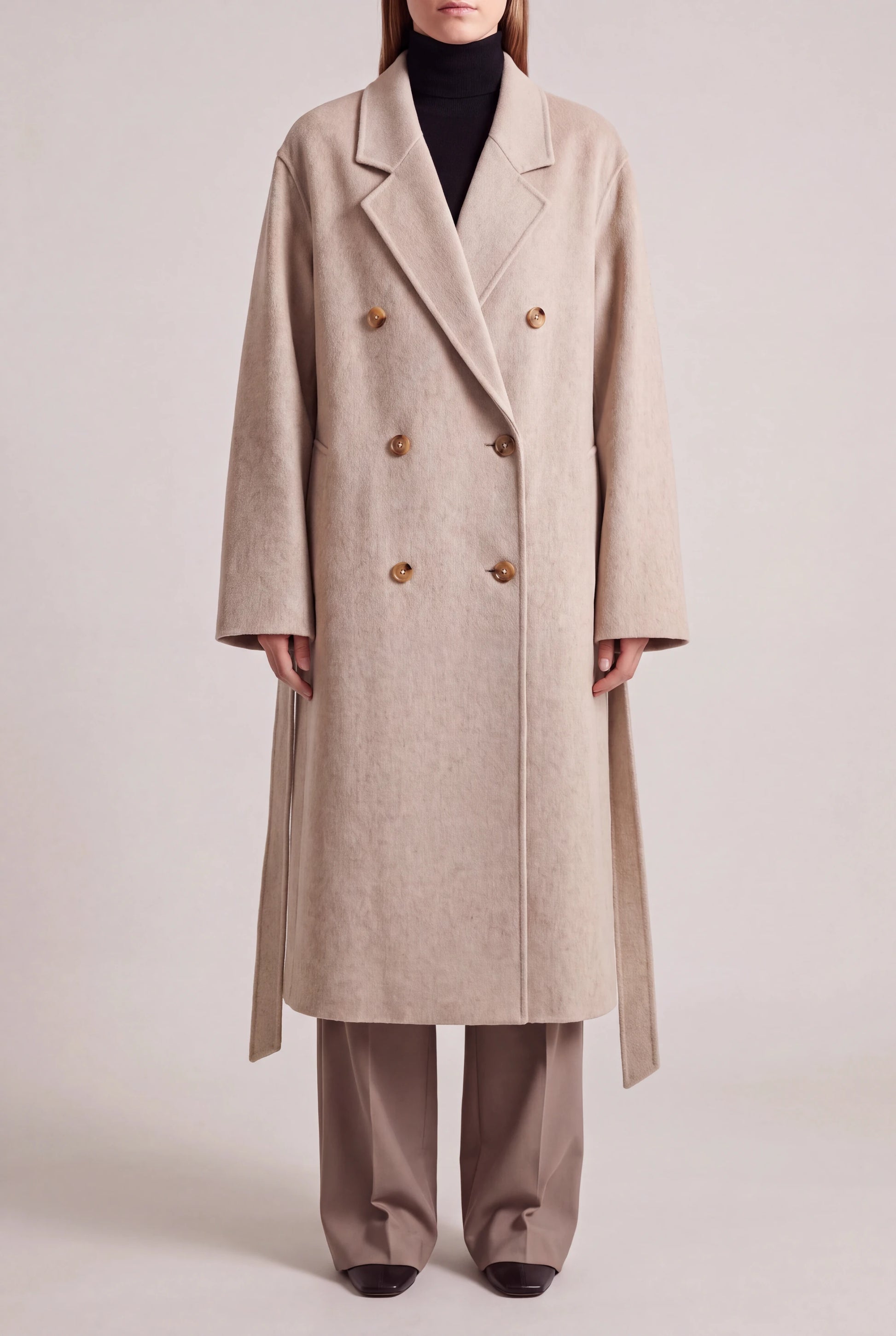 ORABEL lange winterjas voor dames in beige - vooraanzicht met losse ceintuur langs de heupen
