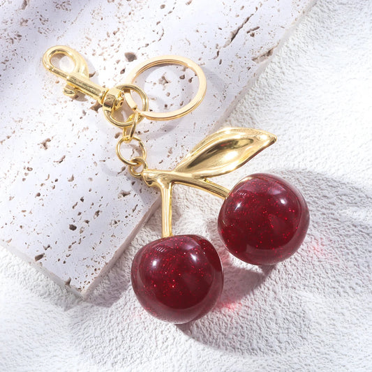 Kersen sleutelhanger dames – glanzend accessoire met gouden details en rode glitterkersen